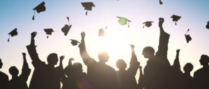 people throwing graduation caps in air